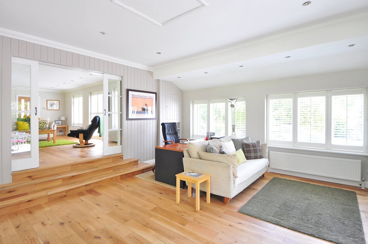 Services-01 Spacious and bright modern living room with wooden floors and stylish furniture.